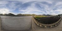 a 360 - angle view of an open road and roadway with mountains in the background