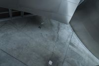 an aerial view of a man walking down stairs next to a building, surrounded by stairs