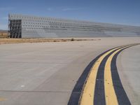 a commercial jetliner parked at an airport runway as a bus drives on the road