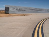 a commercial jetliner parked at an airport runway as a bus drives on the road