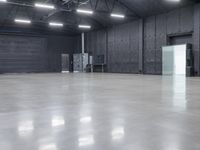 a empty industrial building with large gray floors and a white freezer and refrigerator in front of door