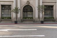 there is a white arrow painted on the street corner in front of the building to indicate where the intersection of two directions