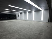 a large parking garage with lights that are attached to the ceiling and concrete flooring