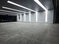 a large parking garage with lights that are attached to the ceiling and concrete flooring