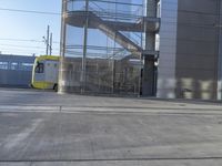 the light rail train is passing through the building's front entrance door and onto the track