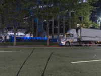 a semi truck is parked in a parking lot at night time, with a white cab or trailer