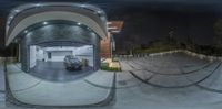 the 360 - view of an empty garage and street in which there is a black car parked