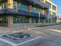 a modern building with an automatic parking spot for cars on the front sidewalk on the corner