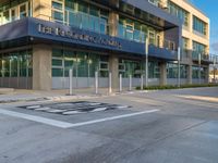 a modern building with an automatic parking spot for cars on the front sidewalk on the corner