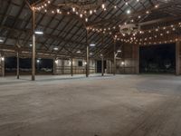 a barn with a lot of lights and wooden floors and a round area to the side