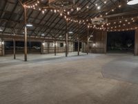 a barn with a lot of lights and wooden floors and a round area to the side