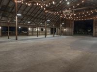 a barn with a lot of lights and wooden floors and a round area to the side