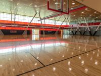 a basketball court and net inside an indoor gym building with bright colors and wooden floors