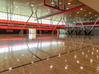 a basketball court and net inside an indoor gym building with bright colors and wooden floors