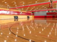 the court is wooden and has high ceilings and a red paneled ceiling with light fixtures