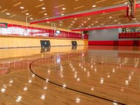 the court is wooden and has high ceilings and a red paneled ceiling with light fixtures