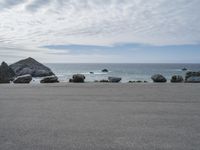 several large rock formations at the beach in front of a body of water with rocks on either side