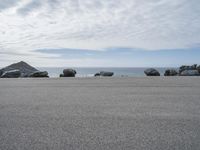 several large rock formations at the beach in front of a body of water with rocks on either side