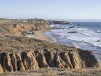 an ocean and some cliffs with a light house in the distance in the distance is a cliff formation