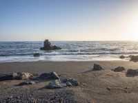 a grassy field by the shore and a cliff with rocks in the ocean in the background