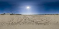 an image of a beach from 360x lens with the sun peeking behind the ground