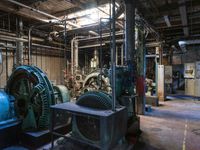 a large blue machine in a building with pipes and valves to be used as machines