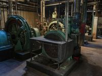 a large blue machine in a building with pipes and valves to be used as machines