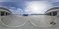 a circular fisheye photograph taken from inside of a building and the parking area underneath it