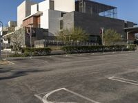 an empty parking lot in front of an art museum and museum building and cars are parked outside the building