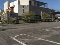 an empty parking lot in front of an art museum and museum building and cars are parked outside the building