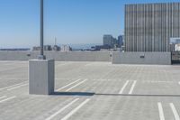 an empty parking lot with white lines and a city in the background on a sunny day