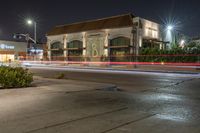 street lights in the background on a city street corner in the foreground with a building lit up