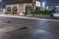 street lights in the background on a city street corner in the foreground with a building lit up