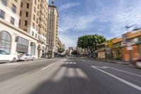 an empty city street with many cars driving on it, in a blurry photo