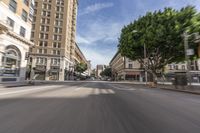 an empty city street with many cars driving on it, in a blurry photo