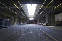 the inside of an empty building looking into an empty parking lot with vehicles parked underneath it