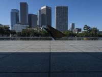 a person with their umbrella on the ground near water and tall buildings behind them in a city