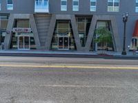 a empty street and building near a red fire hydrant in front of it with a sign for a store in front