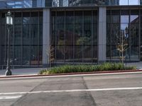 the side of a large building with a lot of glass windows and the bottom floor is covered in a cement and concrete pattern