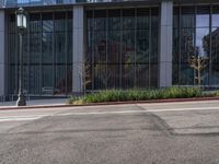 the side of a large building with a lot of glass windows and the bottom floor is covered in a cement and concrete pattern