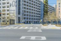 empty street in the city with tall buildings and traffic lights and no vehicles crossing the street