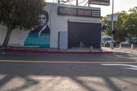 a building painted like obama with a business sign on it's side and a fire hydrant near the street