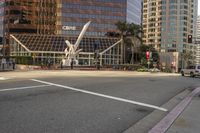 people waiting at a crosswalk while a man is on the street in front of a modern office building