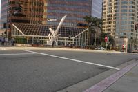 people waiting at a crosswalk while a man is on the street in front of a modern office building