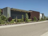 a picture of an outdoor building with plants and trees lining the side of the street