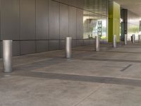 a empty building with grey tiles and green columns in it of what looks like a convention