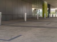 a empty building with grey tiles and green columns in it of what looks like a convention