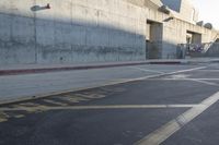 a skateboarder performs a stunt on an empty street while a car drives past