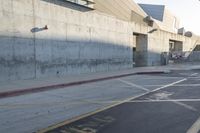 a skateboarder performs a stunt on an empty street while a car drives past