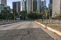 the road is wide and empty next to the city buildings on the other side of the street